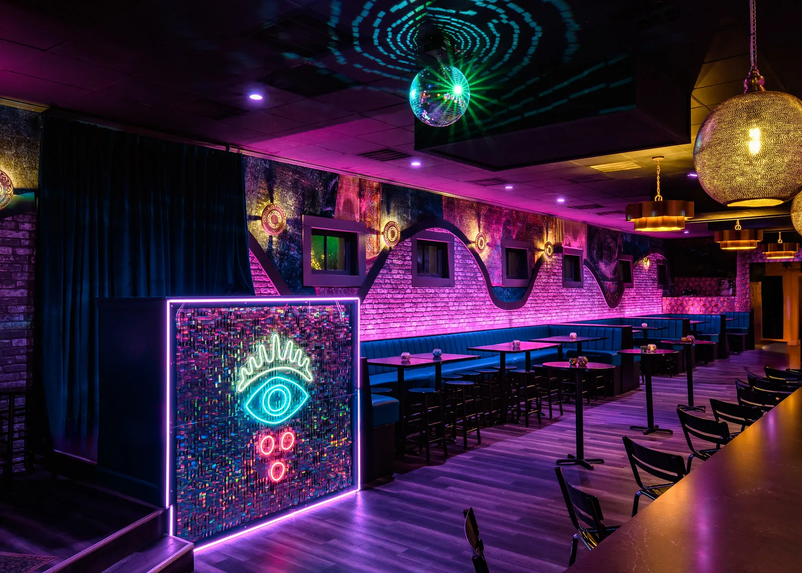 The neon evil-eye wall in the Main Room