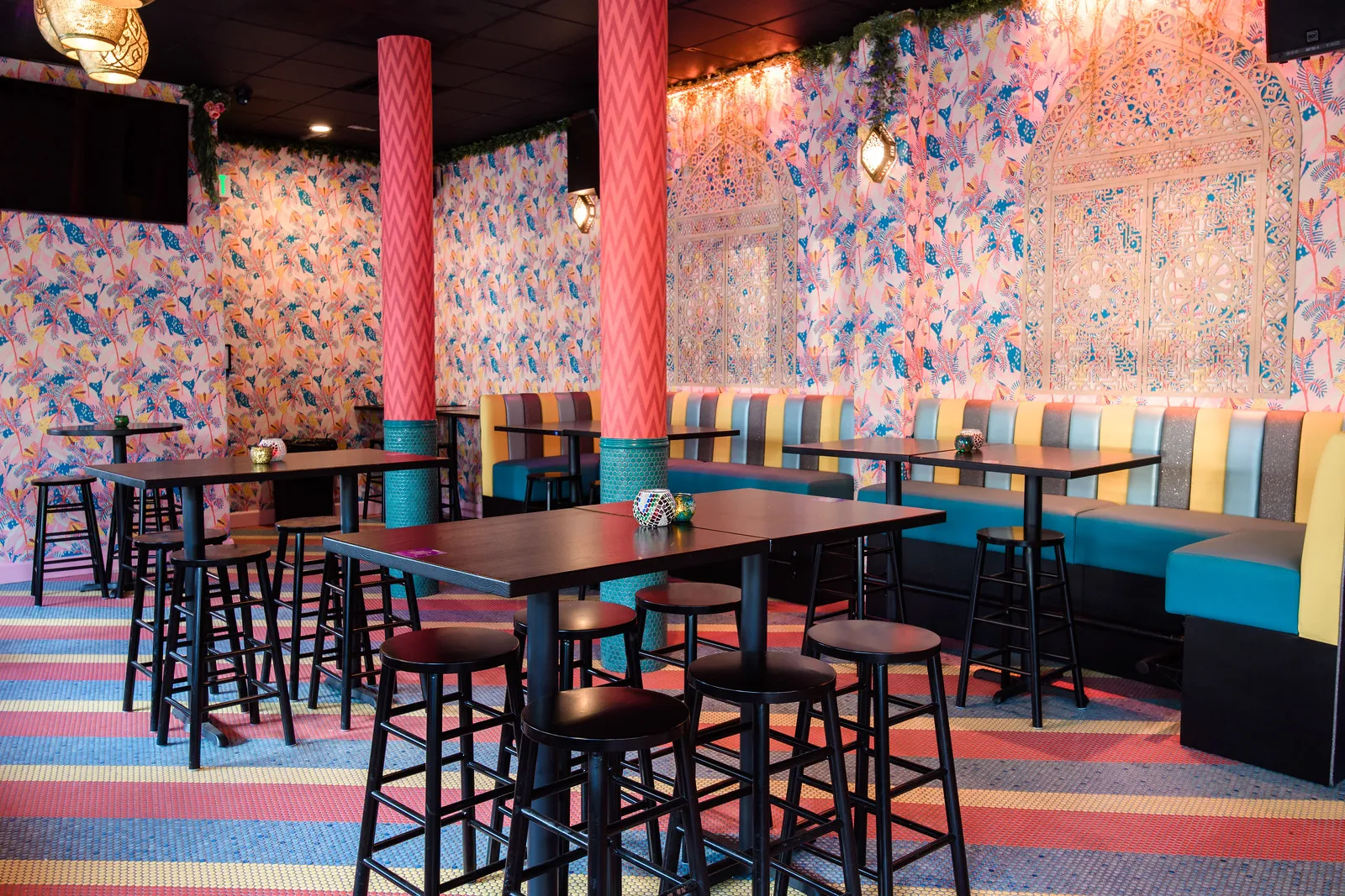The Jungle Room with patterned wallpaper, booths and high tops