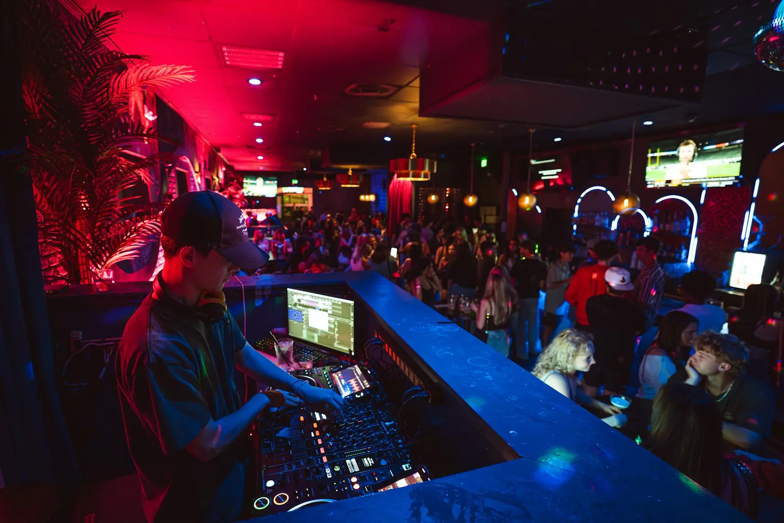 The main room with the DJ booth, TVs and a full dance floor