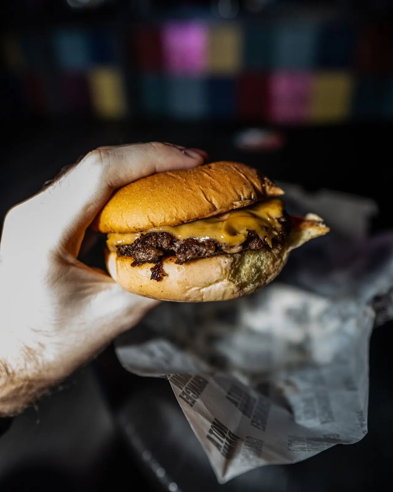 An NADC cheeseburger held up at the bar