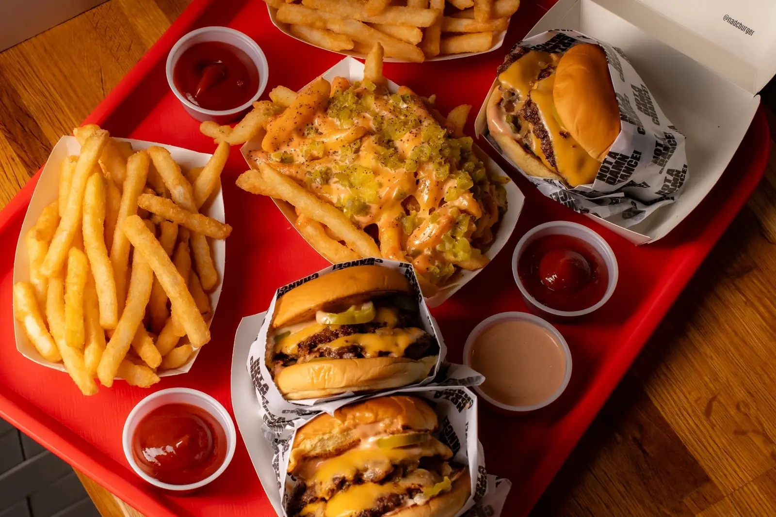 A red tray of NADC burgers, fries and dipping sauces